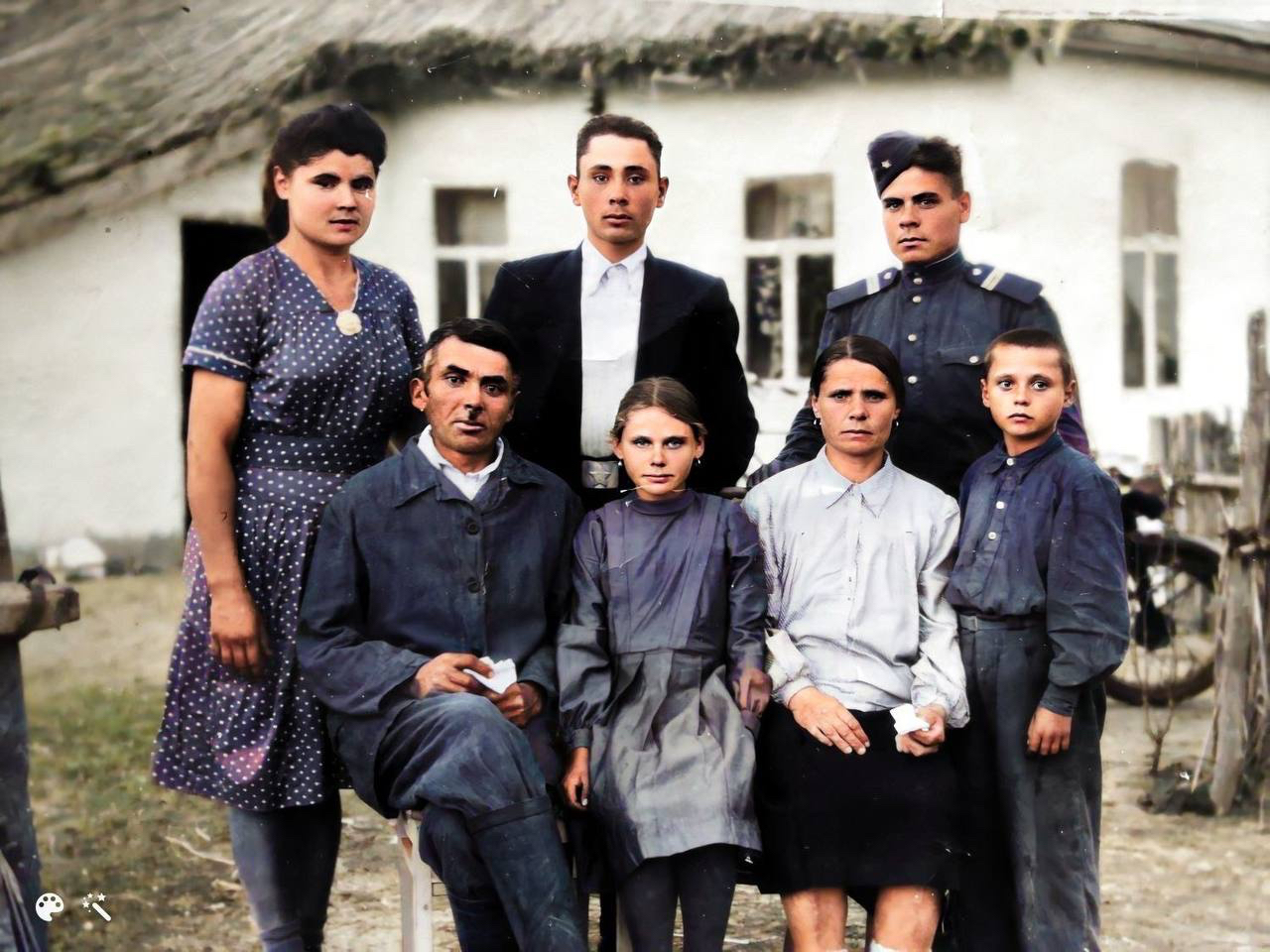 Колоризированное семейное фото на фоне дома с камышовой крышей