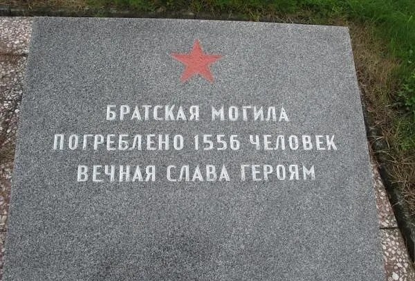 Гранитная плита братской могилы советских воинов: красная звезда и надпись «Братская могила. Погребено 1556 человек. Вечная слава героям»